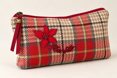 Angled view of Atenti Holly Plaid Tall Tool Pouch, showing red plaid fabric, floral applique and a red zipper pull.