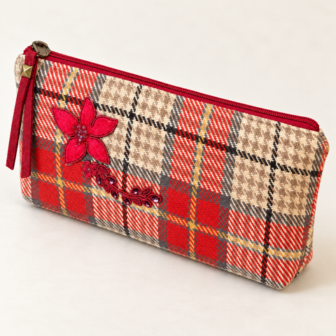 Side angle of Atenti Holly Plaid Tall Tool Pouch, showing the red zipper and floral applique on cream and red plaid.