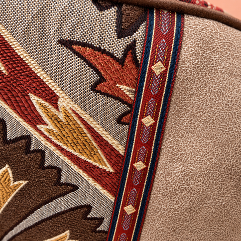 Close-up of brown, rust and gold tapestry, burgundy patterned ribbon and taupe fabric