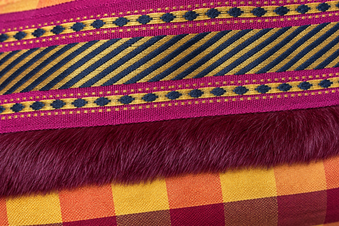 Close-up of colorful woven ribbon and plush burgundy trim on Atenti Cranberry Plaid Tall Tool Pouch.